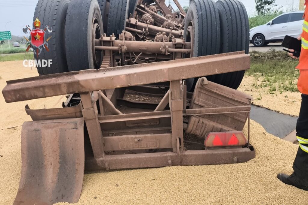 carreta-tomba-na-df-130,-espalha-carga-e-deixa-motorista-ferido