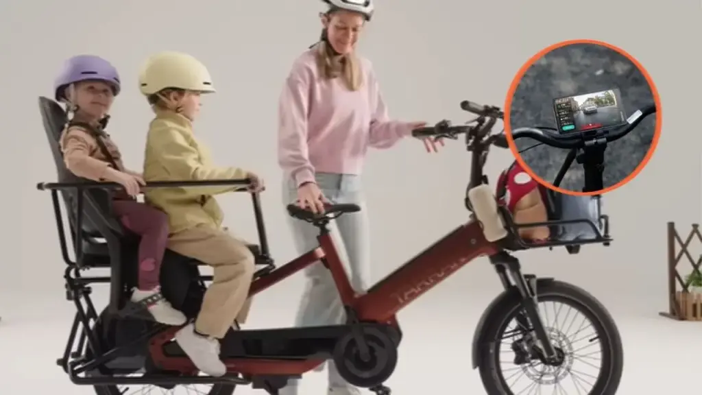 Bicicleta elétrica de carga usa radar automotivo, câmera traseira e descanso acionado por botão para transportar até 215 kg, alcançar 170 km de autonomia e mostrar veículos que se aproximam em uma tela de 5,2 polegadas, enquanto transmissão automática facilita manobras, estacionamento e deslocamentos urbanos com crianças, compras ou entregas pesadas
