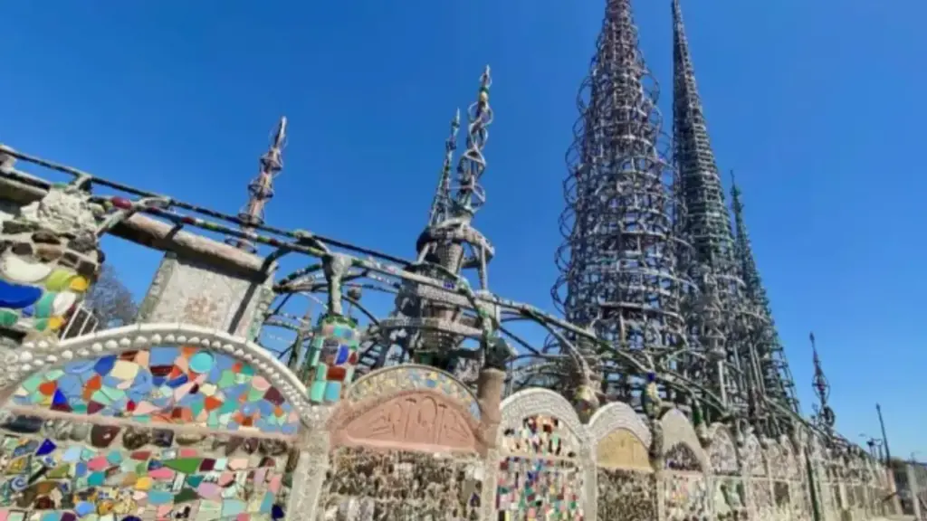 Imigrante italiano passou 33 anos sozinho transformando ferro, vidro quebrado, conchas e restos de lixo em torres de sucata de quase 30 metros em Los Angeles, obra sem projeto que enfrentou ordem de demolição, resistiu a 10 mil libras de força, fez um guindaste falhar e ainda sobreviveu intacta a terremotos históricos