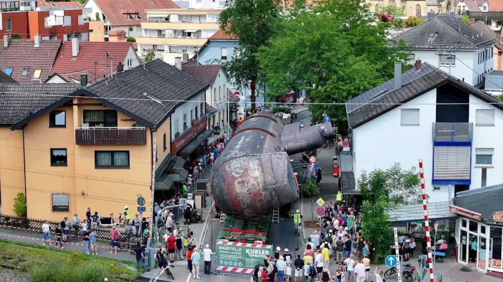 Para percorrer os 39 quilômetros, um submarino de mais de 350 toneladas levou 482 dias, andou a 10 km/h sobre um reboque de 30 eixos e 240 rodas e precisou ser inclinado 73 graus para caber embaixo das pontes do rio