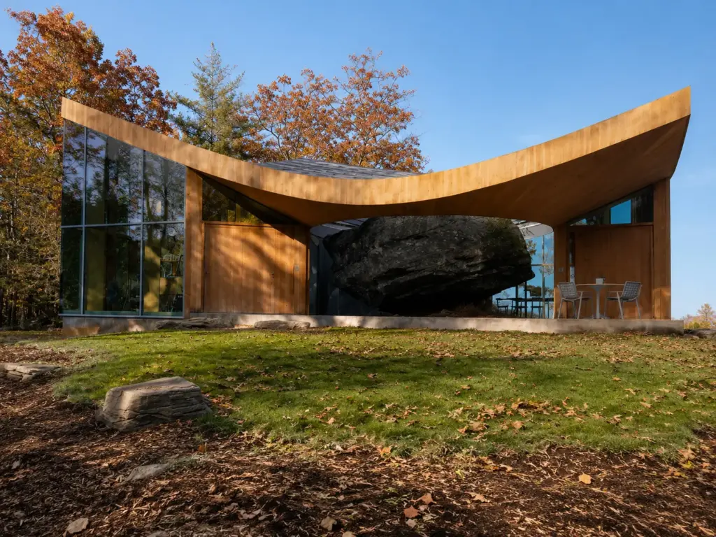 Arquiteto passou sete anos procurando um terreno impossível para morar, encontrou em uma antiga pedreira uma rocha glacial de 12 mil anos e construiu ao redor do bloco, transformando a formação natural no centro da casa onde vive com a mulher e os dois filhos