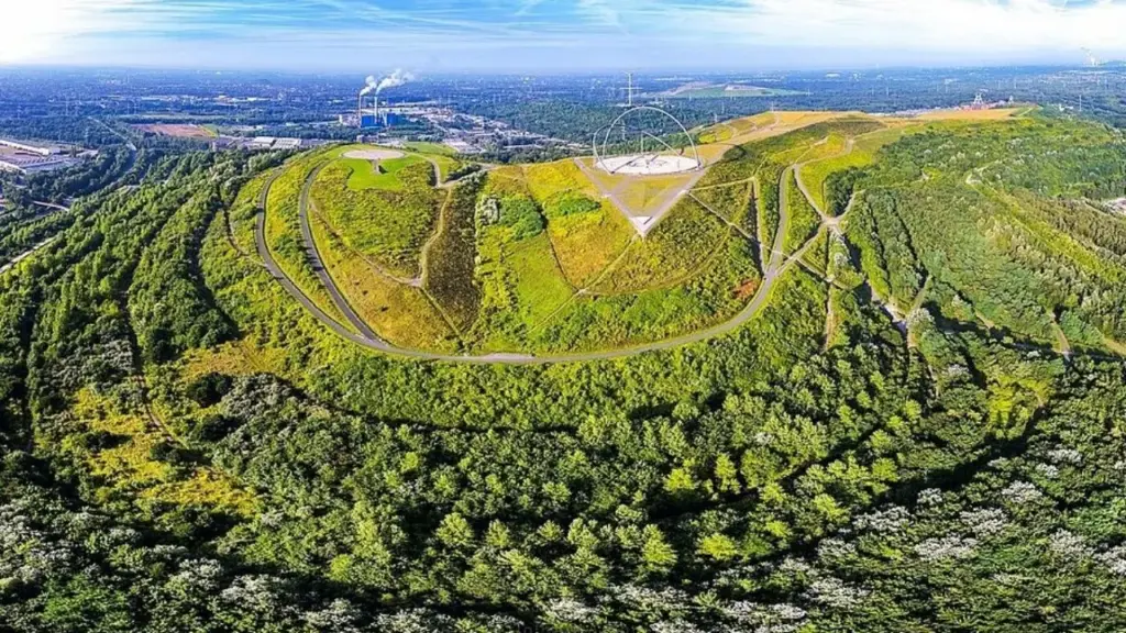 A Alemanha empilhou 180 milhões de toneladas de rejeitos de carvão sobre 170 hectares, ergueu uma montanha artificial de 111 metros e transformou o antigo passivo das minas em parque com observatório, relógio solar gigante, arcos de aço de 45 metros e mais de 500 degraus até um dos mirantes mais incomuns da Europa A Alemanha empilhou 180 milhões de toneladas de rejeitos de carvão sobre 170 hectares, ergueu uma montanha artificial de 111 metros e transformou o antigo passivo das minas em parque com observatório, relógio solar gigante, arcos de aço de 45 metros e mais de 500 degraus até um dos mirantes mais incomuns da Europa