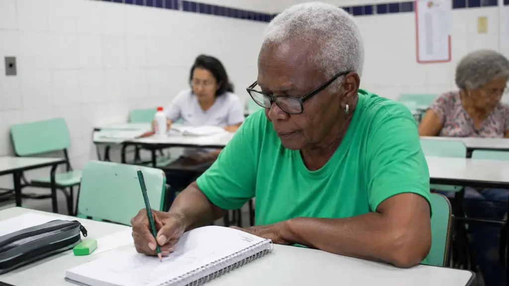 Aos 84 anos, Dona Vivi pega ônibus todos os dias, atravessa Belo Horizonte para estudar e ajuda a revelar um grupo surpreendente de 230 alunos com mais de 80 anos que ainda frequentam a EJA na capital mineira