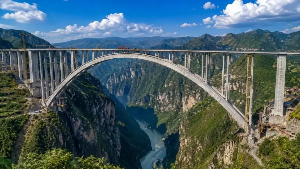 China quebra uma barreira que parecia travar a engenharia há décadas: nova ponte de arco de concreto alcança 600 metros de vão, supera em 155 metros o antigo recorde mundial, usa 22% menos concreto por metro e ainda promete economizar mais de US$ 80 milhões entre construção e manutenção ao longo de 100 anos