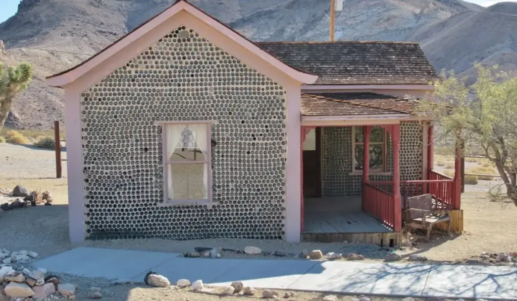 Aos 76 anos, homem percebeu que havia garrafas de cerveja por toda parte e quase nenhuma árvore no deserto de Nevada, então recolheu 51 mil delas em 53 bares, misturou vidro e barro e ergueu uma casa inteira que sobreviveu à cidade ao redor e virou atração de uma cidade fantasma