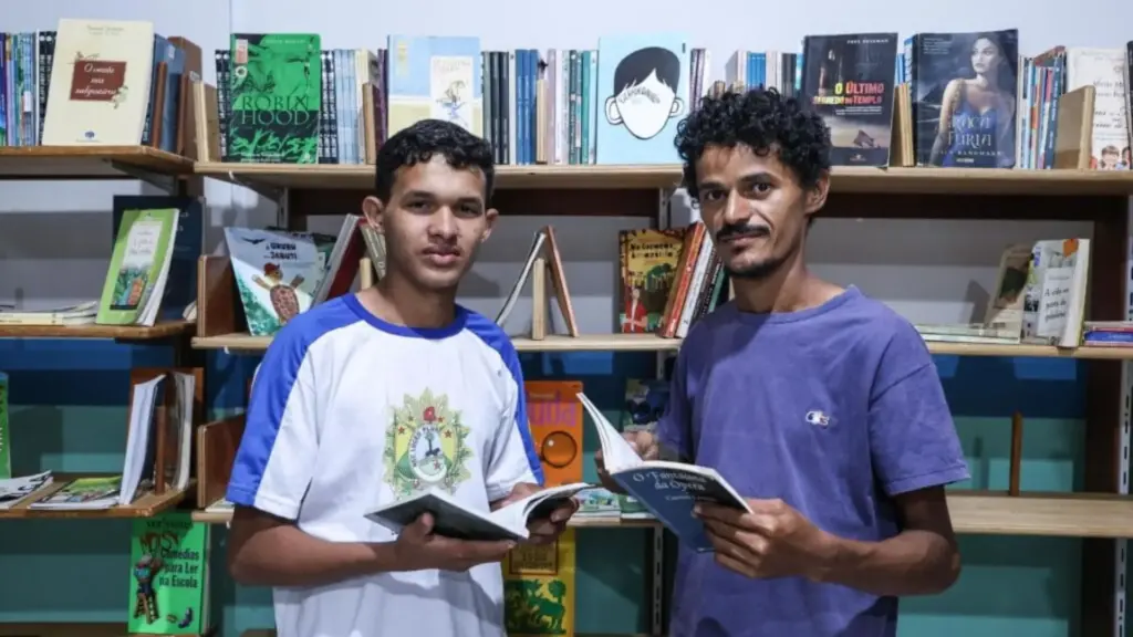 Pai que estudou só até a 3ª série ficou em casa à noite para que o filho e a esposa estudassem, viu o rapaz ser alfabetizado aos 15 e agora voltou à EJA por incentivo dele, enquanto os dois roçam quintais de dia, estudam juntos à noite e o próprio filho o ajuda nas leituras