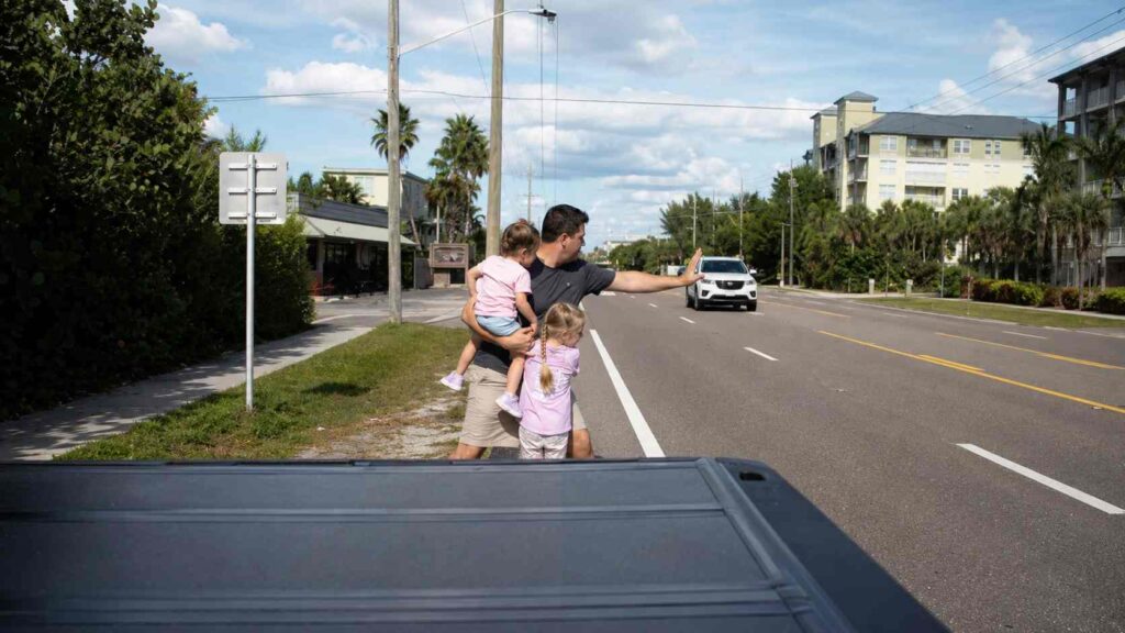 Pai de 5 filhos vê duas meninas de cerca de 2 anos no meio de rodovia movimentada, corre diante dos carros, interrompe o trânsito com uma mão e retira as duas da pista
