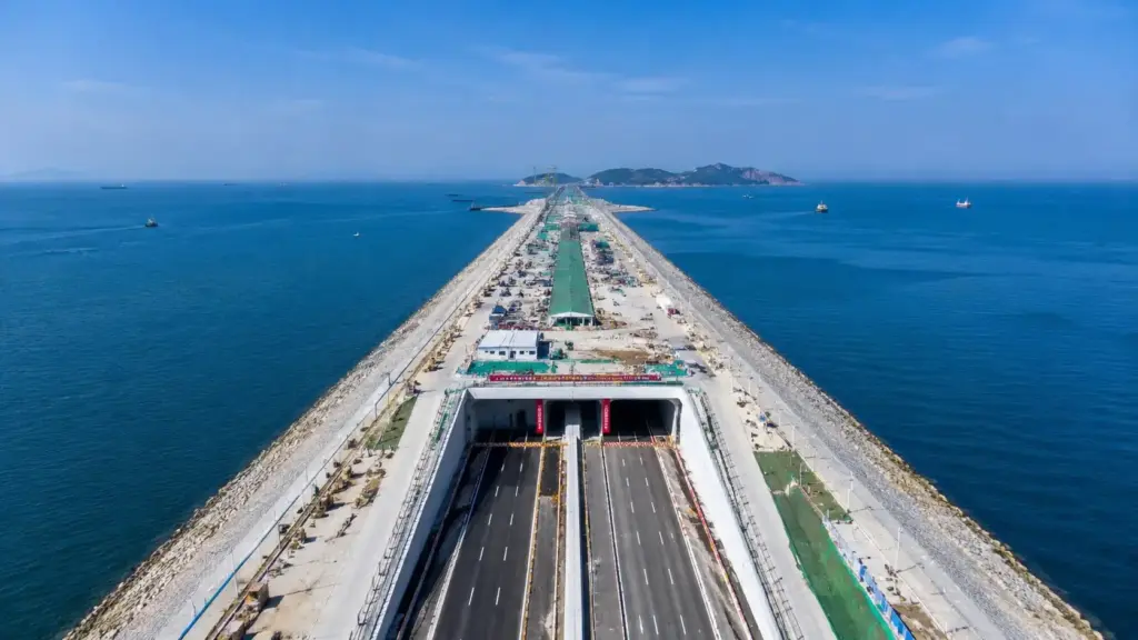 China afundou 18 gigantes de concreto de 60 mil toneladas no fundo do mar, instalou uma peça de 180 metros quase todos os meses e montou em apenas 20 meses um túnel submarino de seis faixas sob a Baía de Dalian