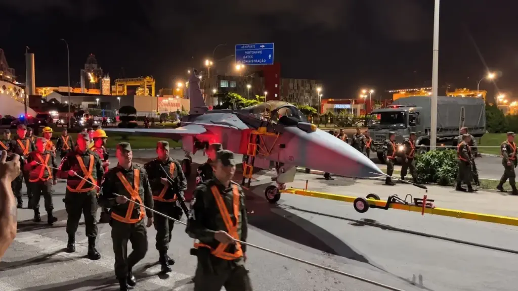 Caça Gripen F-39 zero-km cruza o Atlântico dentro de navio, desembarca de madrugada no Porto de Navegantes e literalmente toma as ruas de Santa Catarina sob escolta da Força Aérea, com trânsito bloqueado e trajeto de cerca de 3 km até um portão do aeroporto criado especialmente para receber essas aeronaves