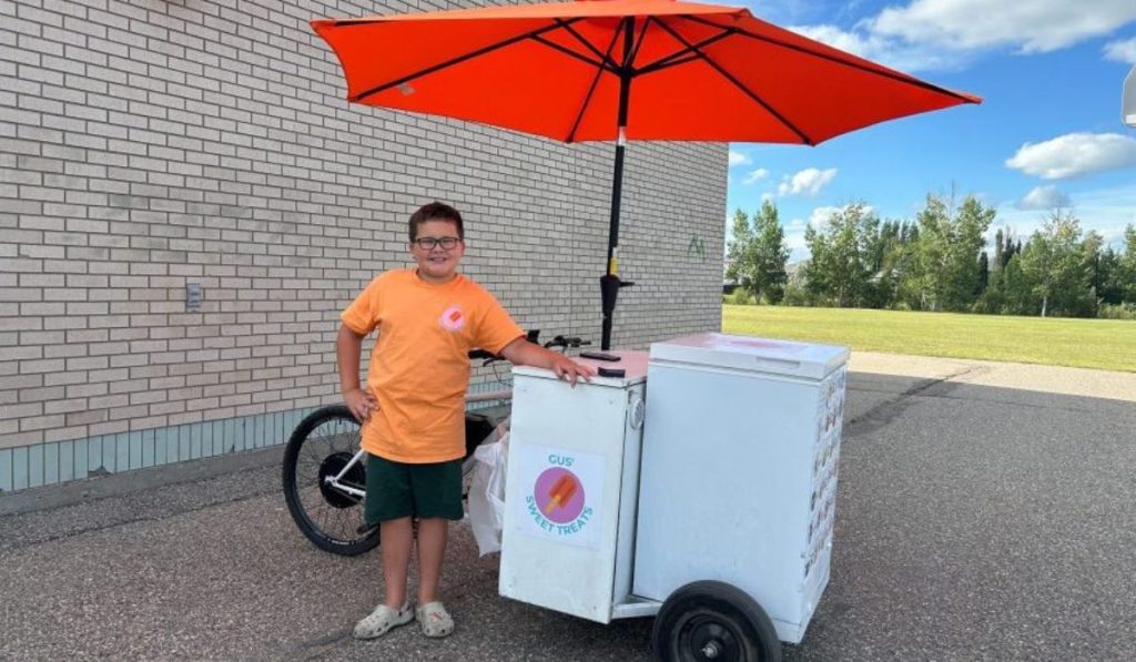Aos 10 anos, garoto vê antiga bicicleta de sorvete durante um jogo no Canadá, pergunta ao pai como aquilo funcionava e decide construir a própria com freezer, inversor e motor elétrico, até começar a rodar pela cidade e atender até 100 clientes por dia