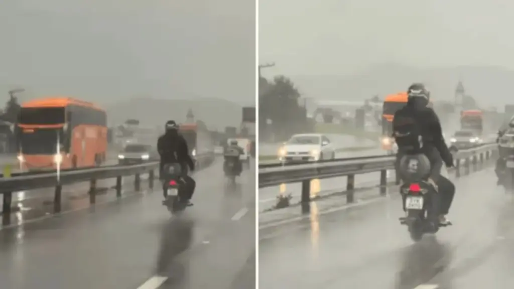 Em plena chuva forte, mulher é flagrada viajando sentada sobre um botijão de gás na garupa de uma motocicleta que seguia pela BR-101, em Itajaí; o flagrante inusitado viraliza, passa de 130 mil visualizações e expõe uma combinação perigosa de passageira, carga improvisada e pista molhada em uma das principais rodovias de Santa Catarina