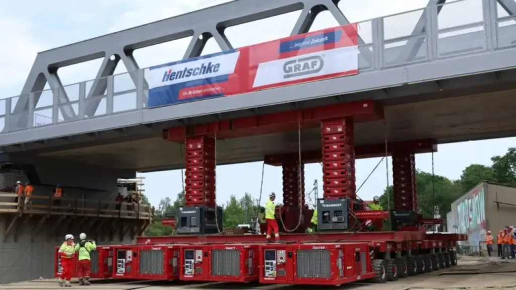 Ponte ferroviária inteira de 750 toneladas atravessa cidade sobre 40 linhas de eixos e é colocada no lugar em operação planejada para reduzir a interrupção dos trens Ponte ferroviária inteira de 750 toneladas atravessa cidade sobre 40 linhas de eixos e é colocada no lugar em operação planejada para reduzir a interrupção dos trens